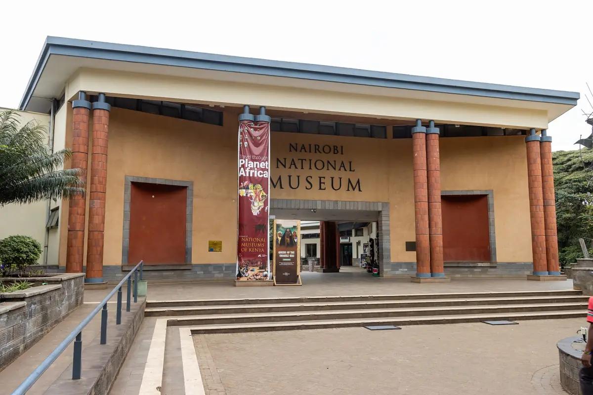 Entrance of the Nairobi National Museum with red columns and a banner